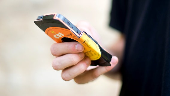 Eine Handy-Schutzhülle liegt in der Hand eines jungen Mannes. © dpa-Bildfunk Foto: Julian Stratenschulkte