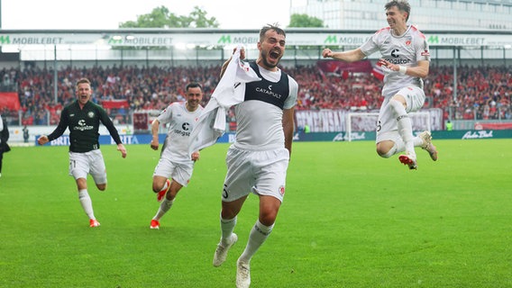 St. Paulis Danel Sinani (M.) und seine Mitspieler bejubeln einen Treffer. © IMAGO / Steinbrenner 